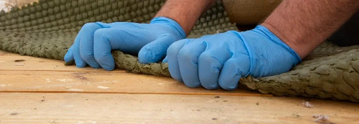 Hände entfernen Teppich von Holzboden